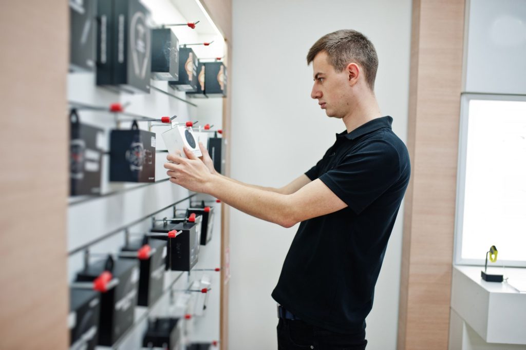 Salesperson showing a tech product inside an electronics store