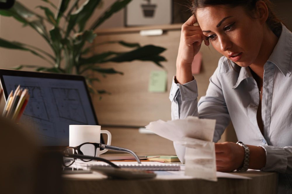 Businesswoman feeling worried about financial debts and analyzing bills